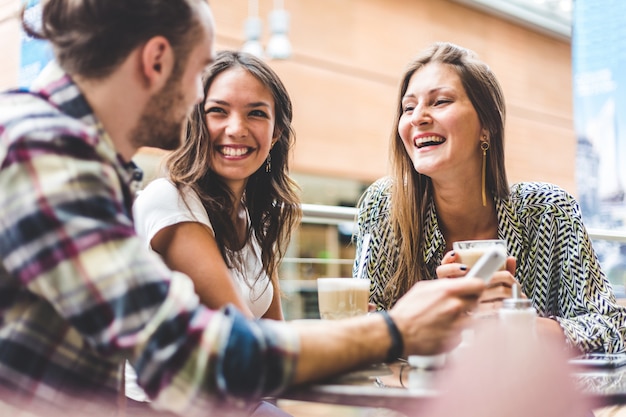 Grupo multirracial de amigos tomando um café juntos