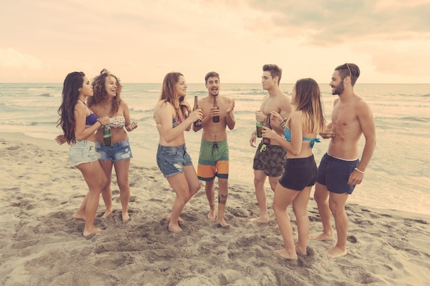 Grupo multirracial de amigos, uma festa na praia