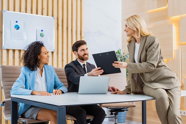 Grupo multirracial de empresários com vestido elegante sentado na mesa do computador no escritório