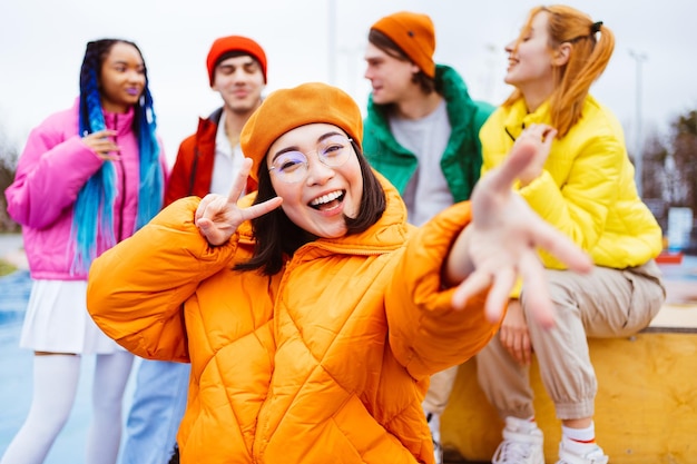 Grupo multirracial de jovens amigos reunidos ao ar livre no inverno