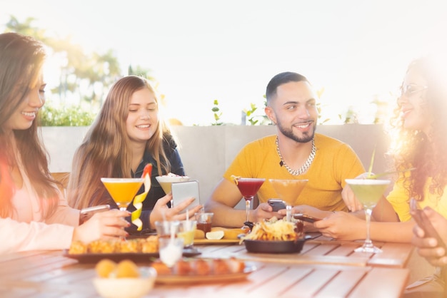 Grupo multirracial de jovens amigos se divertindo no restaurante conversando e rindo enquanto jantava