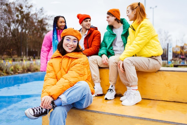 Grupo multirracial de jóvenes amigos reunidos al aire libre en invierno