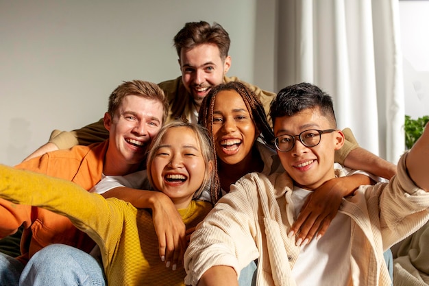 grupo multirracial de jóvenes amigos sonriendo y tomando selfies para la cámara asiático afroamericano