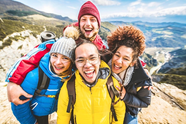 Grupo multirracial de jóvenes caminando montañas juntos