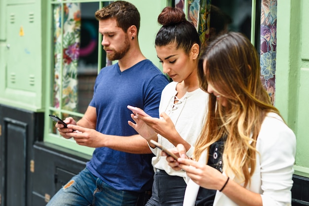 Grupo multirracial de personas mirando hacia abajo en el teléfono inteligente