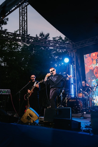 Foto grupo musical, banda, no palco em raios brilhantes