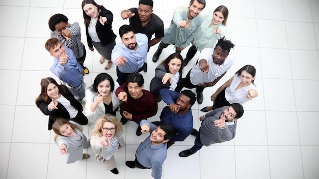 Grupo de negocios multicultural de éxito mirando hacia arriba en el pasillo de la oficina