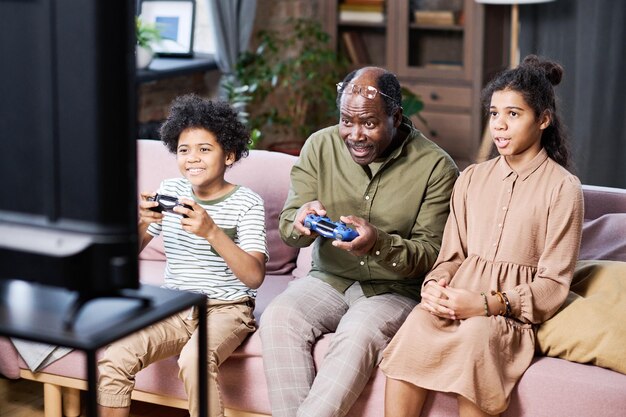 Grupo de nietos felices y su abuelo jugando juegos de ocio