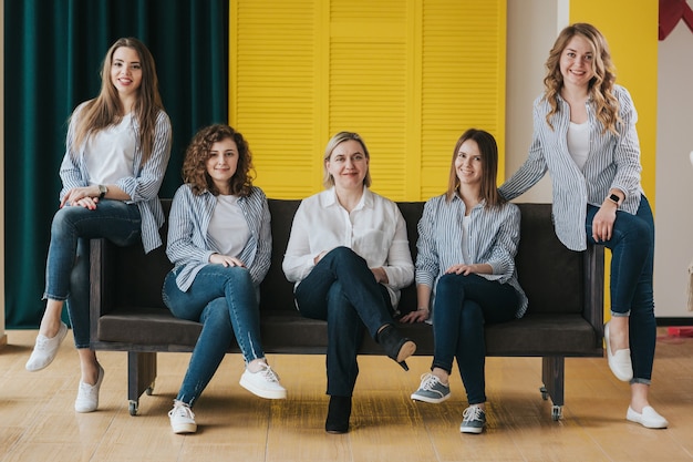 Grupo de niñas felices posando en el sofá. foto de estudio.