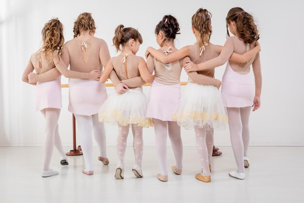 Niñas bailando ballet en el estudio jóvenes bailarinas estirándose antes de  la actuación de danza clásica