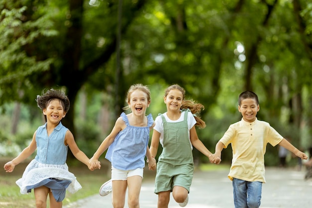 Grupo de niños asiáticos y caucásicos divirtiéndose en el parque