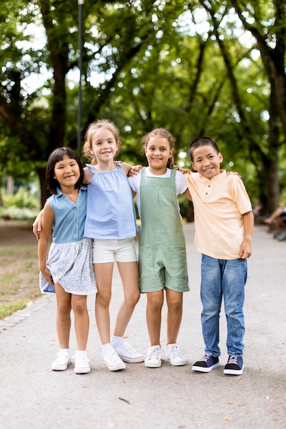 Foto grupo de niños asiáticos y caucásicos divirtiéndose en el parque