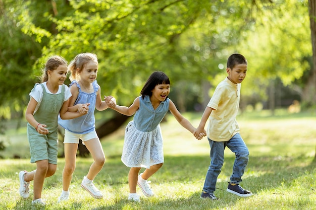 Grupo de niños asiáticos y caucásicos divirtiéndose en el parque