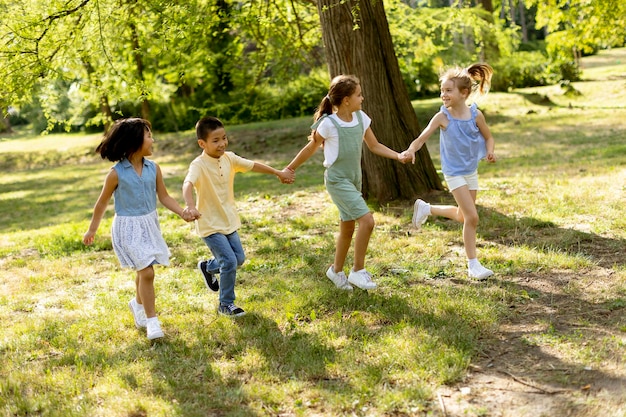 Grupo de niños asiáticos y caucásicos divirtiéndose en el parque