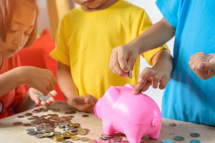 Grupo de niños asiáticos están ayudando a poner monedas en la hucha o