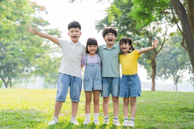 Un grupo de niños asiáticos lindos divirtiéndose en el parque.