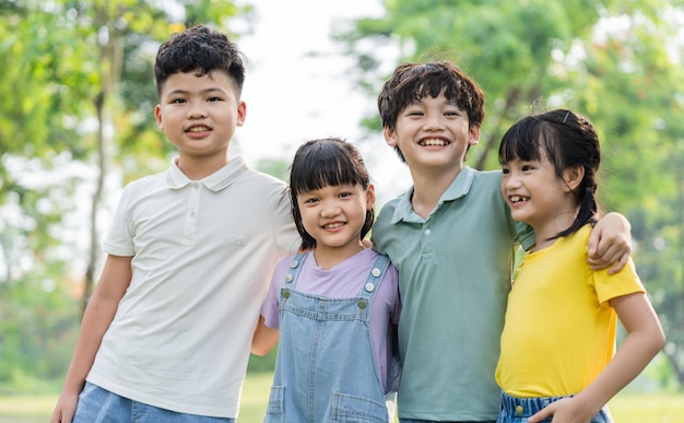 Un grupo de niños asiáticos lindos divirtiéndose en el parque.