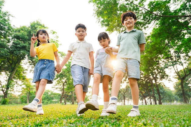 Un grupo de niños asiáticos lindos divirtiéndose en el parque.