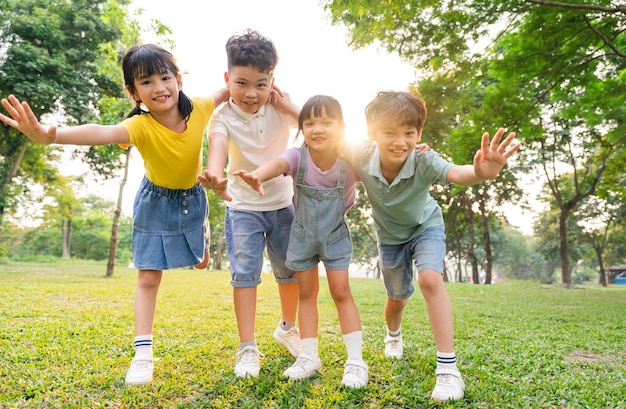 Un grupo de niños asiáticos lindos divirtiéndose en el parque.