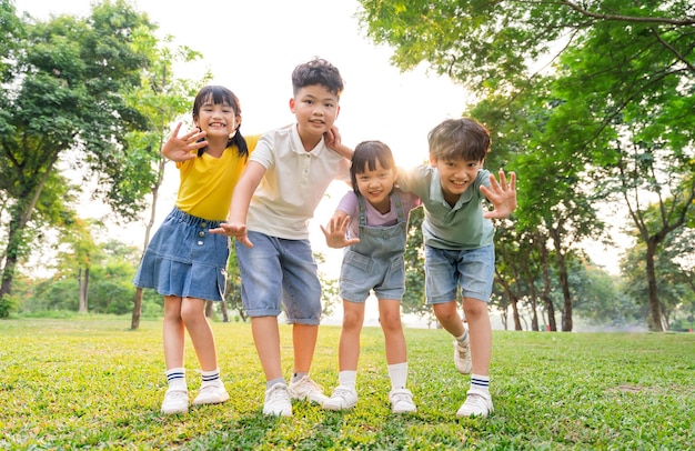 Un grupo de niños asiáticos lindos divirtiéndose en el parque.