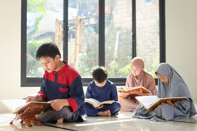 Grupo de niños asiáticos musulmanes leyendo Corán junto con amigos en la mezquita