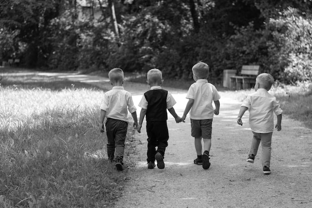 Grupo de niños corriendo a lo largo del camino hacia la cámara en el parque