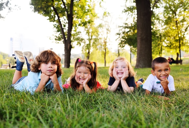 Grupo de niños en edad preescolar jugando en el parque en la hierba