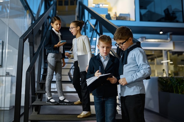 Grupo de niños empresarios hablando en escalera