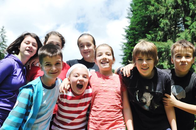 Foto grupo de niños felices divertirse al aire libre en la naturaleza en suny día