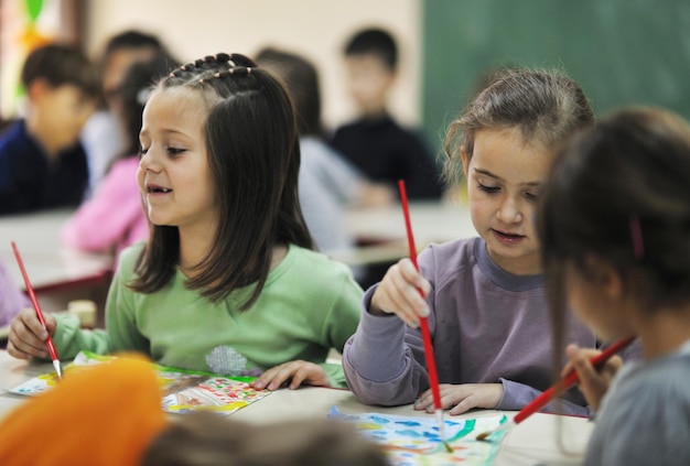 el grupo de niños felices se divierten y juegan en el concepto de educación preescolar interior de jardín de infantes con el maestro