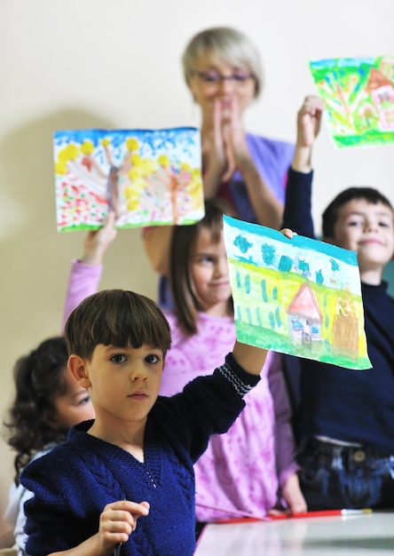 el grupo de niños felices se divierten y juegan en el concepto de educación preescolar interior de jardín de infantes con el maestro