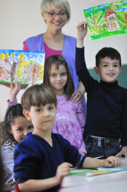 el grupo de niños felices se divierten y juegan en el concepto de educación preescolar interior de jardín de infantes con el maestro