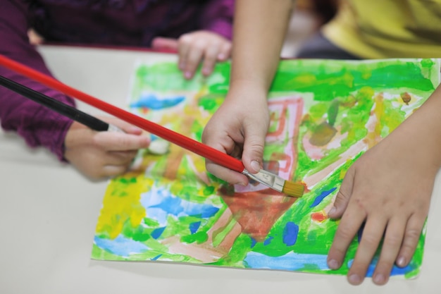 el grupo de niños felices se divierten y juegan en el concepto de educación preescolar interior de jardín de infantes con el maestro