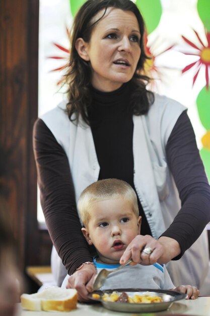 Foto el grupo de niños felices se divierten y juegan en el concepto de educación preescolar interior de jardín de infantes con el maestro