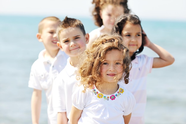 grupo de niños felices en la playa que se divierten y juegan