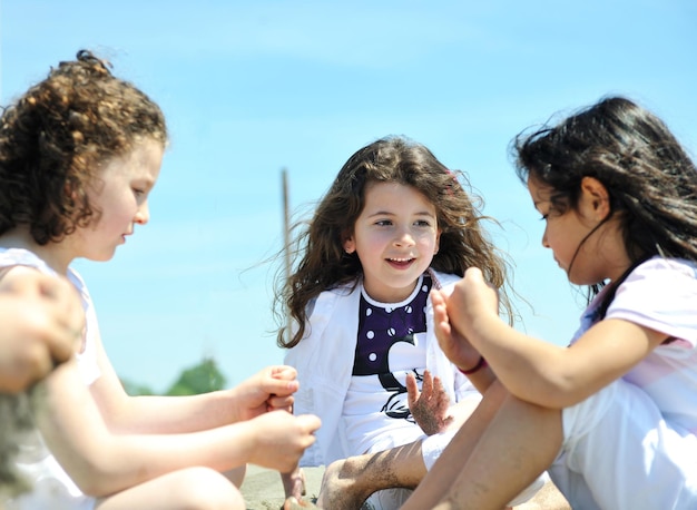 grupo de niños felices en la playa que se divierten y juegan