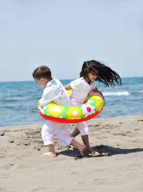 grupo de niños felices en la playa que se divierten y juegan