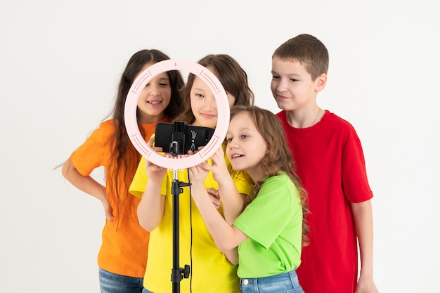 Grupo de niños felices sonriendo y grabando un video