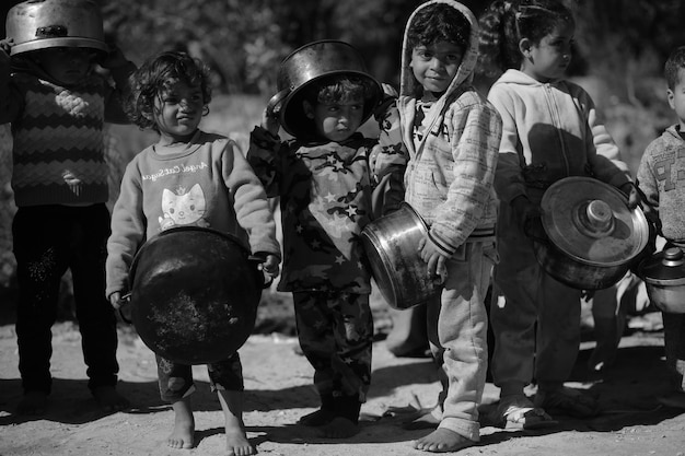 Un grupo de niños forman una fila con un gato al frente.