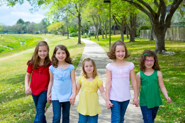 Grupo de niños de hermanas chicas y amigos caminando en el parque