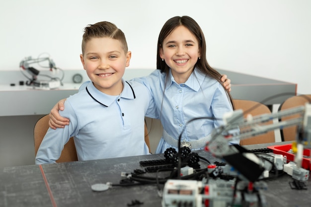 Grupo de niños jugando con robots ensamblados a partir de piezas de plástico.