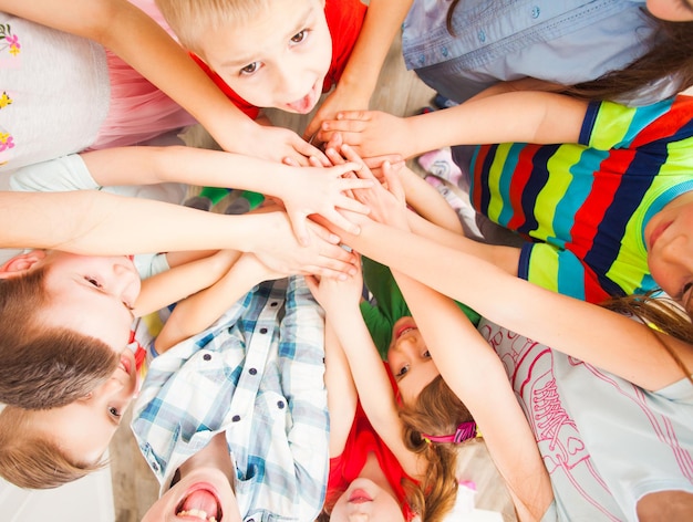 Grupo de niños juntando las manos. Vista superior