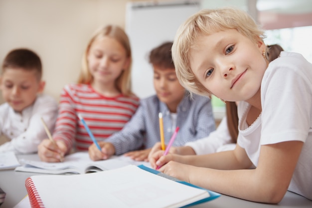 Grupo de niños lindos dibujando juntos en clase de arte