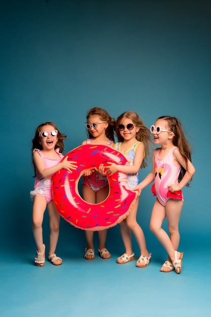 Grupo de niños niñas en trajes de baño y gafas de sol.