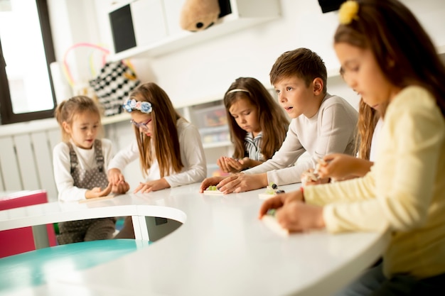 Grupo de niños pequeños jugando con juguetes educativos de madera preescolar