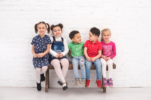 Foto grupo de niños sentados en un banco