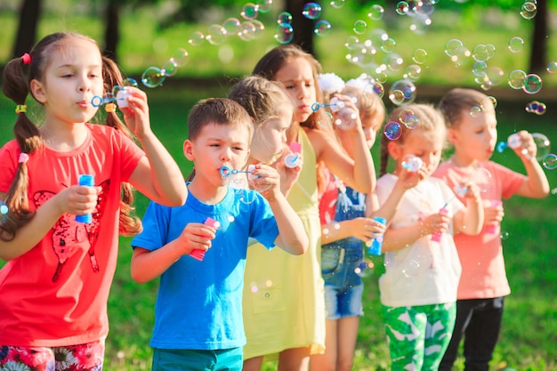 Grupo de niños soplando pompas de jabón