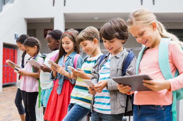 Grupo de niños con teléfono móvil y tableta digital