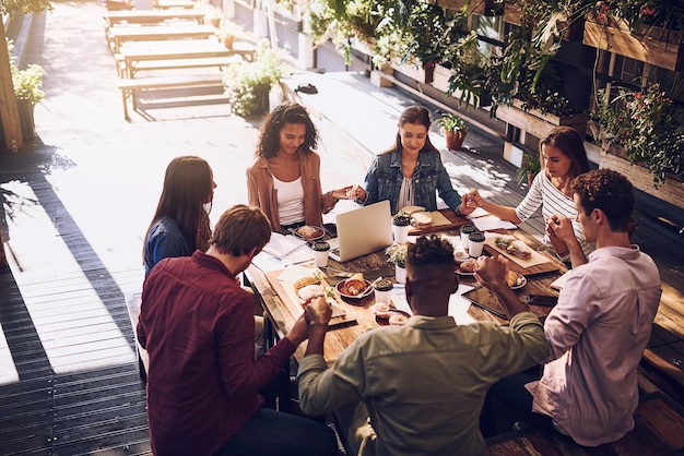 Grupo de oración y personas que se toman de la mano para la planificación financiera de los alimentos y los documentos presupuestarios del trabajo en equipo al personal gracias y respeto de la reunión con los gráficos de papeleo y las ganancias para la contabilidad en la cafetería juntos