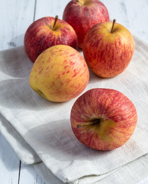 Un grupo de pequeñas manzanas rojas sobre una mesa de madera